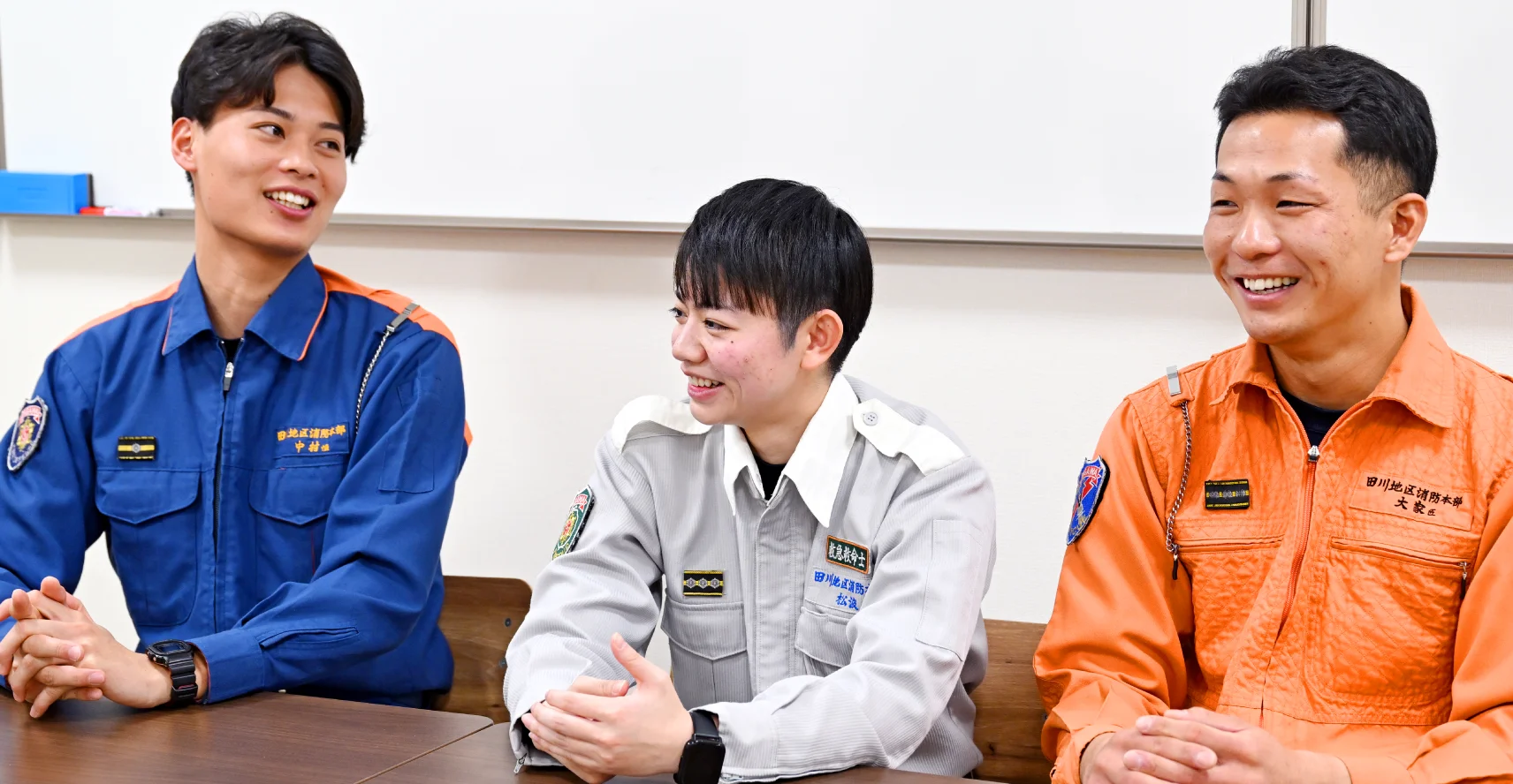 長机の椅子に座っている中村さん、松浪さん、大家さんがインタビュー中に笑い合っている様子