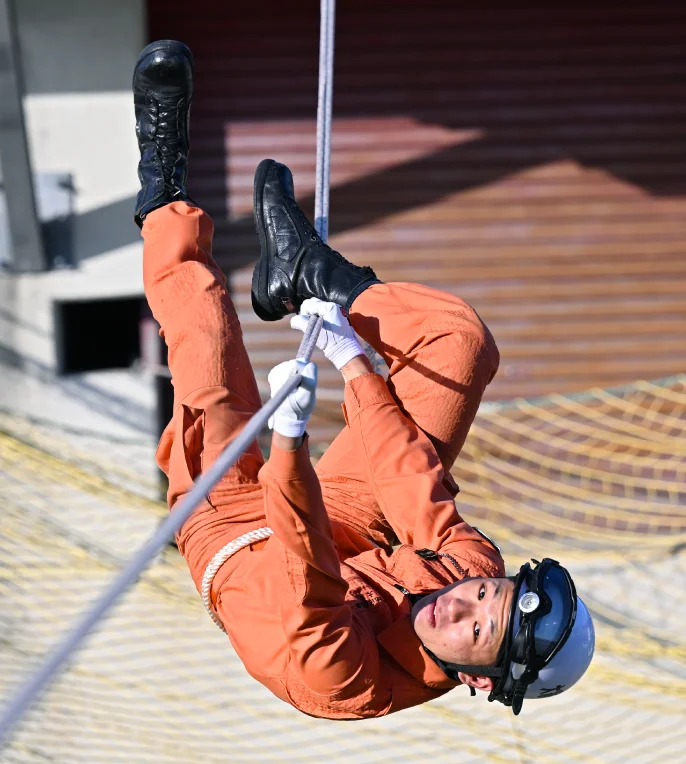 逆さまでロープに掴まっている大家さんの様子